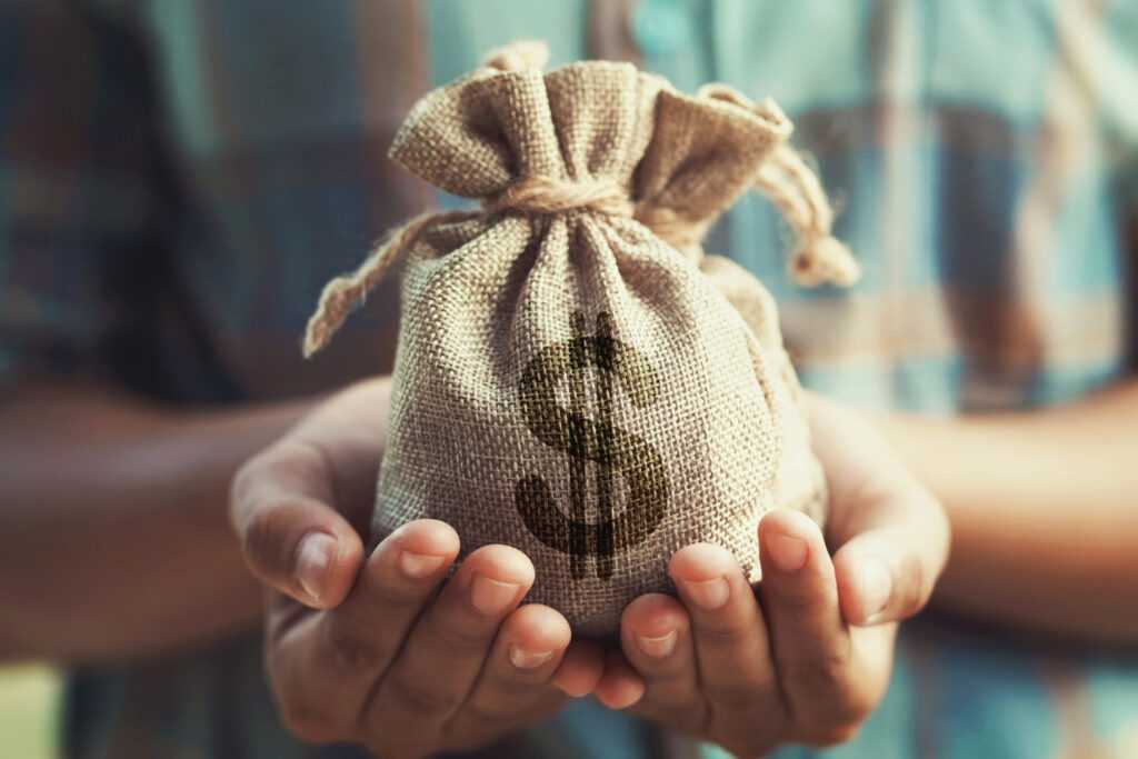 woman hand holding money bag concept saving finance accounting 1024x683