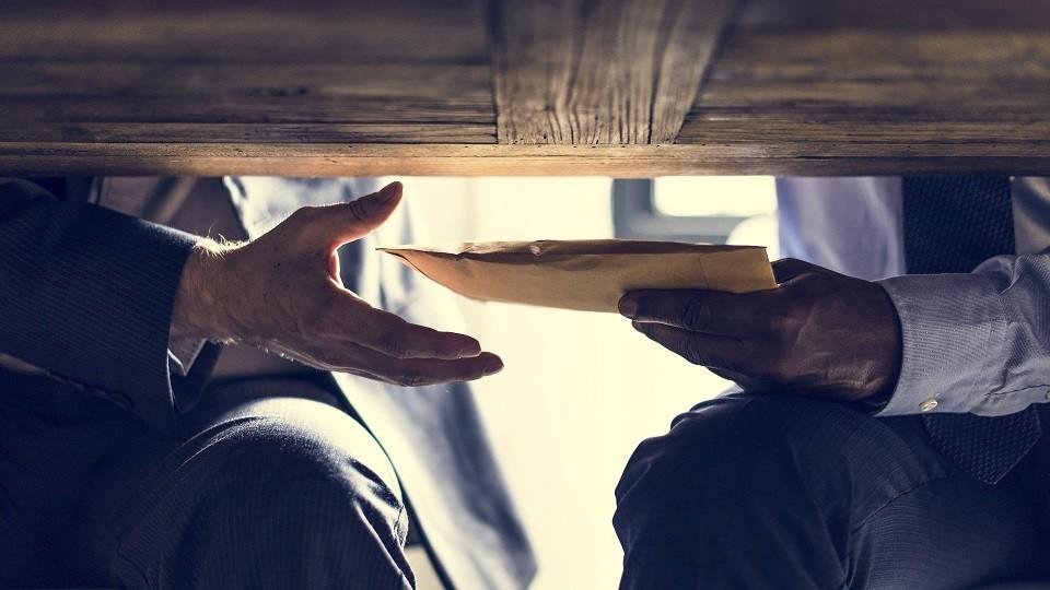 Business people sending documents under the table