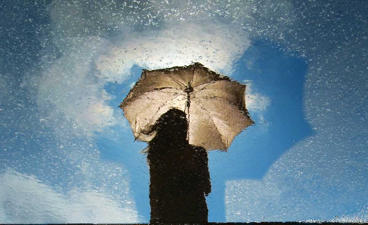 person standing on gray surface while holding umbrella