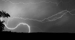 Captivating lightning strike against a cloudy night sky, captured in monochrome.