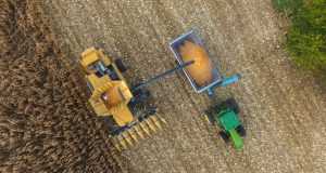 an aerial view of a tractor and a combine in a field