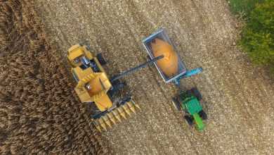 an aerial view of a tractor and a combine in a field