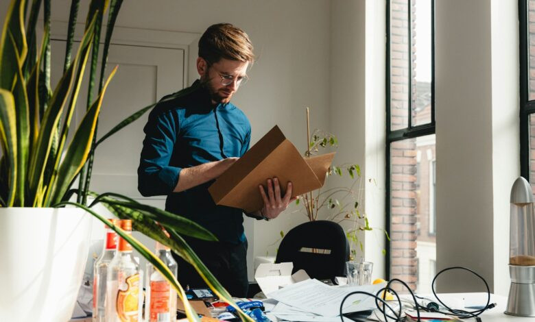 a man standing in an office holding a box
