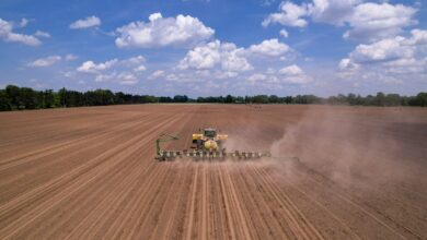 a tractor plowing a field with a sprayer