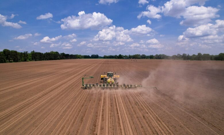 a tractor plowing a field with a sprayer