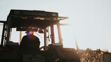 silhouette of man riding tractor