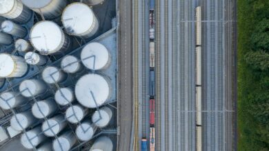 Overhead view of industrial silos and a train on tracks.