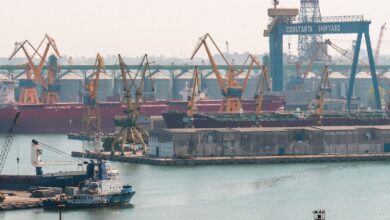 A busy scene at Constanta Shipyard, Romania, featuring cranes and cargo ships in the harbor.
