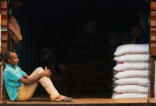 Man sitting on truck tailgate with stacked white bags