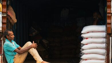 Man sitting on truck tailgate with stacked white bags