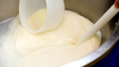 a bowl filled with white liquid and a plastic spoon