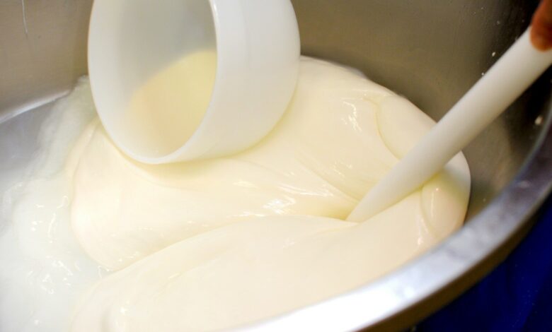 a bowl filled with white liquid and a plastic spoon