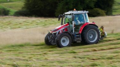 a tractor is driving through a field of grass
