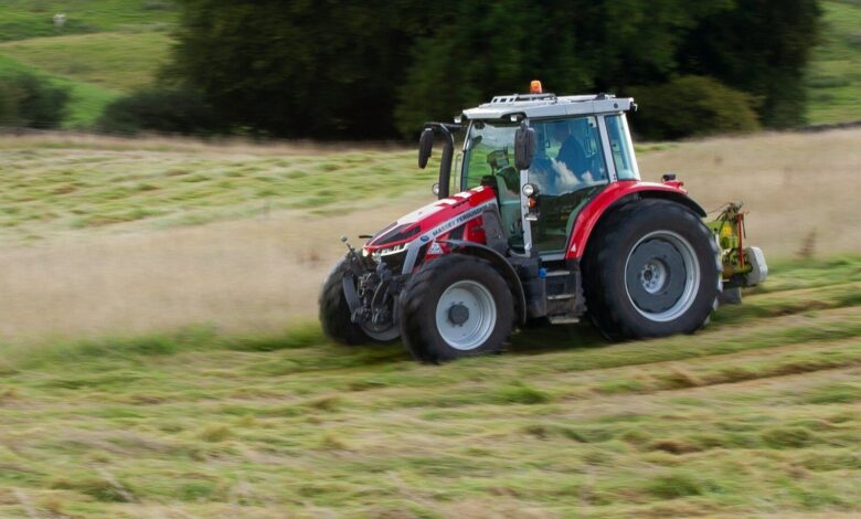 a tractor is driving through a field of grass