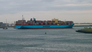 a large blue cargo ship in the middle of a body of water
