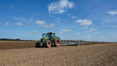 Tractor plowing a field under a blue sky