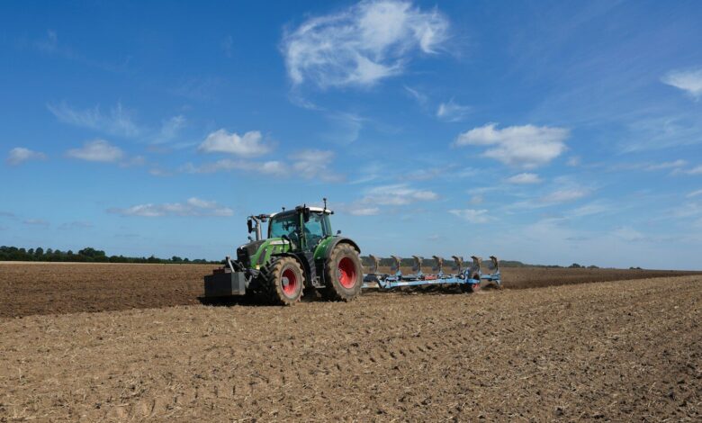 Tractor plowing a field under a blue sky